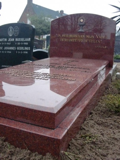 liggende grafzerk met staande steen en bronze letters