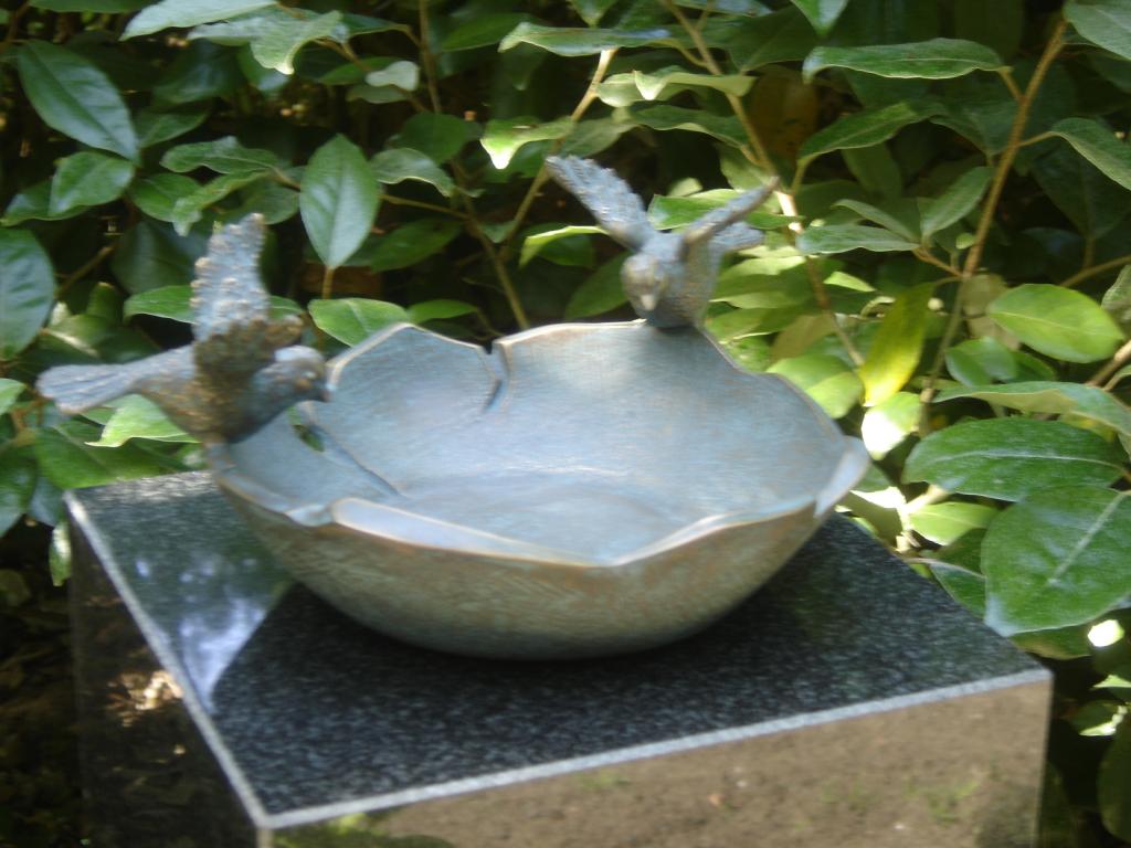 Bronzen vogelbak op grafsteen